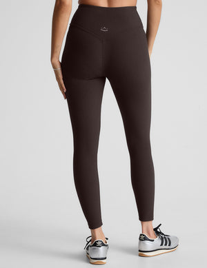 model wearing brown ribbed high-waisted midi length leggings against a plain background. 