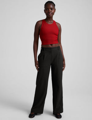 model is wearing a red ribbed high-neck racerback cropped tank top against a plain background. 