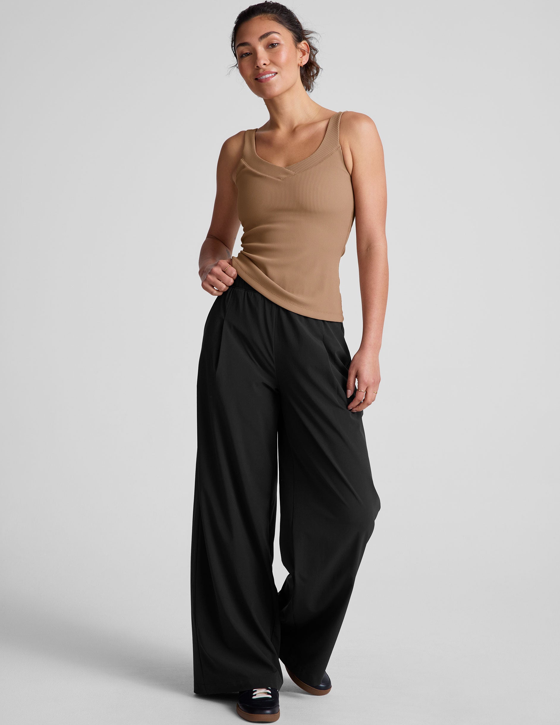 brown classic length tank top with a soft V neckline front and back​, overlapping front neckline detail, and a performance lining shelf bra. Tank hits at a high hip length. 