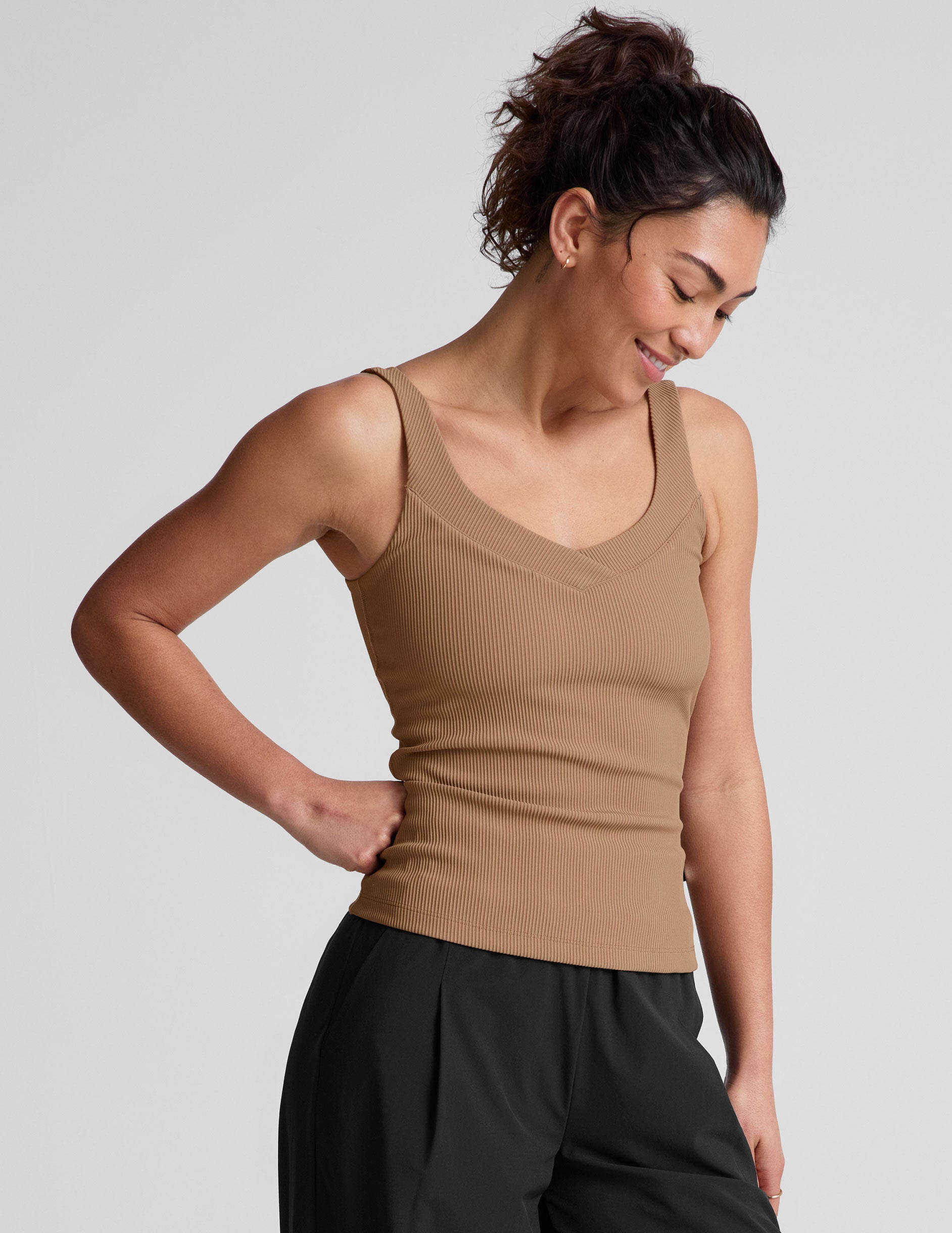 brown classic length tank top with a soft V neckline front and back​, overlapping front neckline detail, and a performance lining shelf bra. Tank hits at a high hip length. 