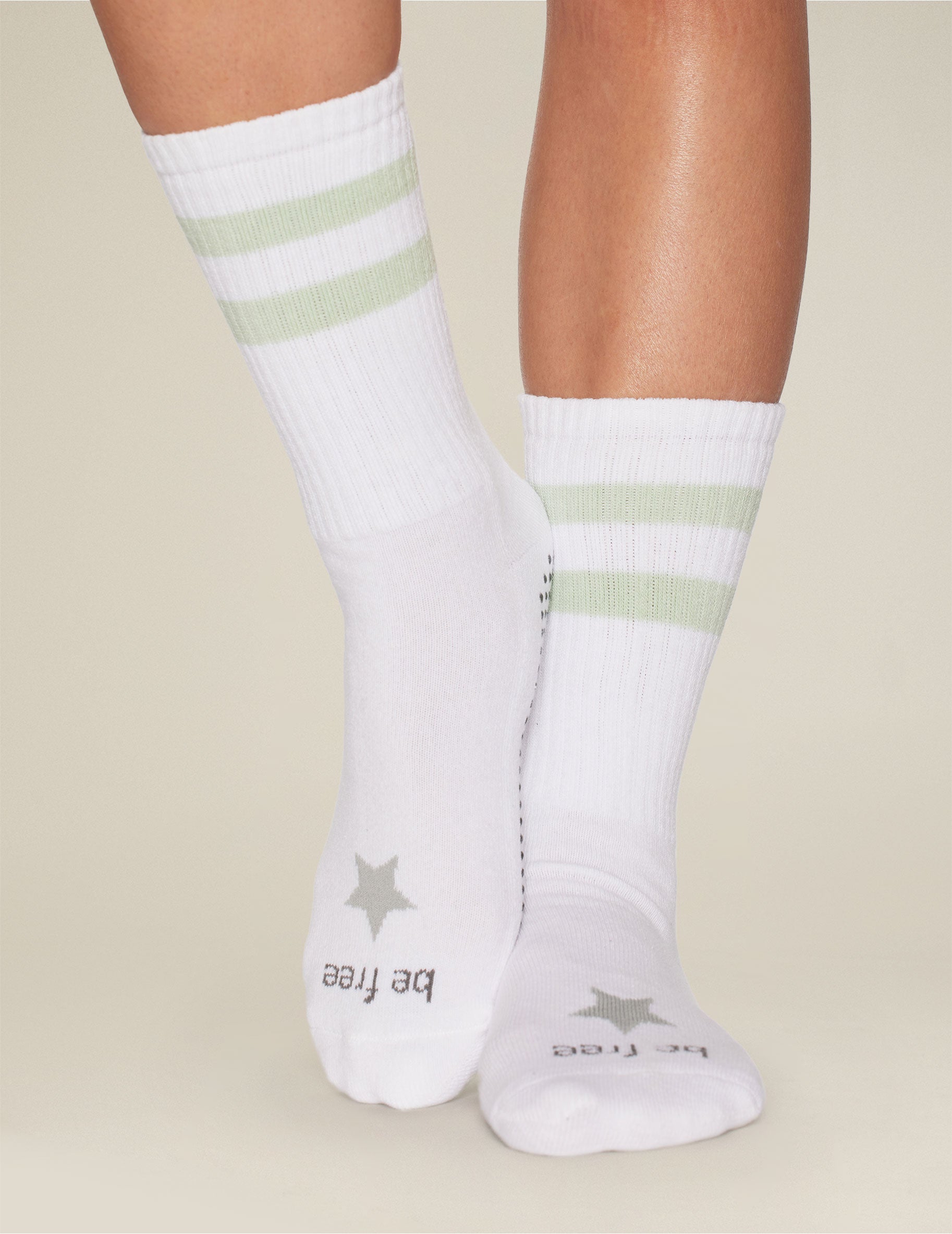 white crew length socks with green stripe detailing. 
