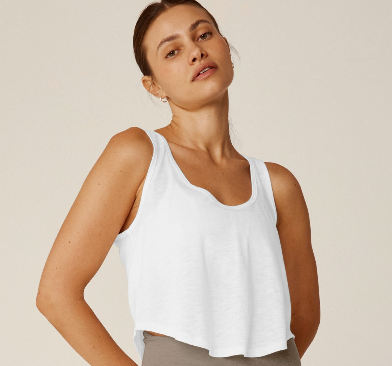 model is wearing a white scoop neck cropped tank top. 