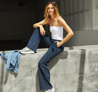 model is wearing blue high-waisted flare pants with pockets. 