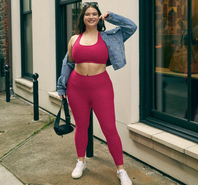 model is wearing a red bra top and red high-waisted midi leggings. 