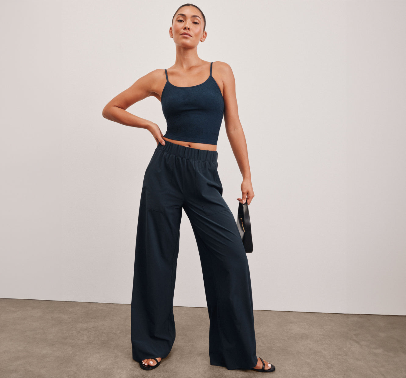 model is wearing a blue waist length tank and blue wide leg pants. 