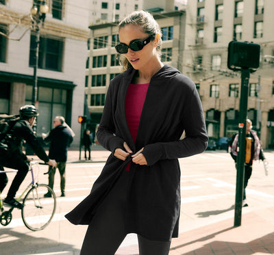model is wearing a black midi length jacket. 