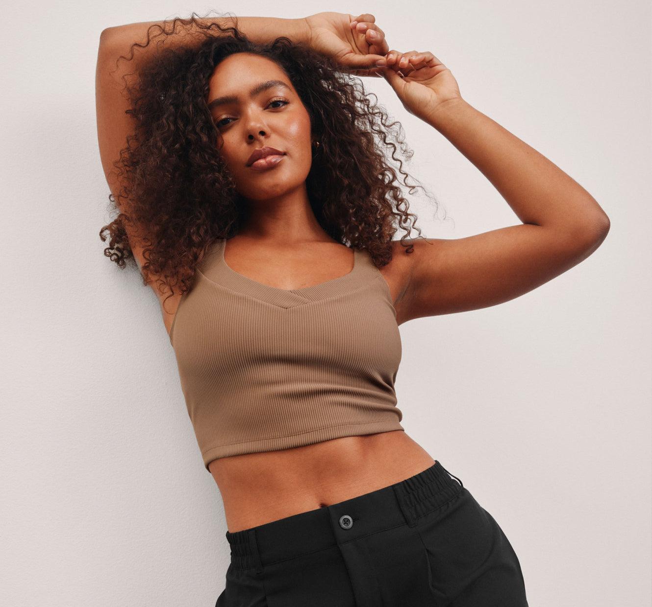 model is wearing a brown ribbed tank top. 