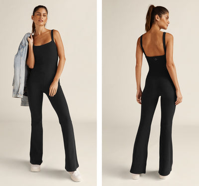 model is wearing a black flare pant jumpsuit. 