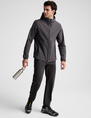 Man wearing a gray hooded jacket on a light gray background. 