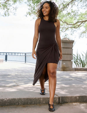 Woman wearing a brown midi length wrap dress. 