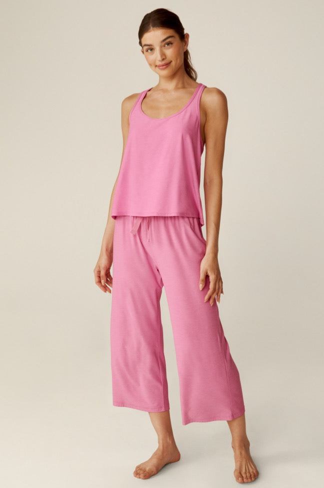 model is wearing a pink sleep tank top and pink sleep cropped pants. 