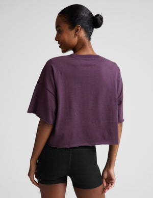 Person wearing a purple t-shirt and black shorts on a plain background