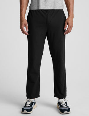 man wearing black pants on a plain background. 