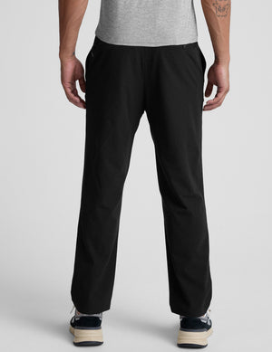 man wearing black pants on a plain background. 