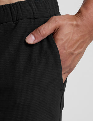 man wearing black pants on a plain background. 