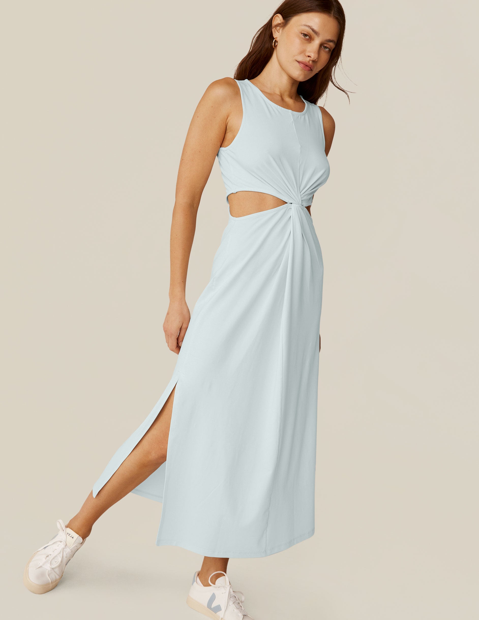 model is wearing a blue tank top maxi dress with a twist detailing and side cutouts. 