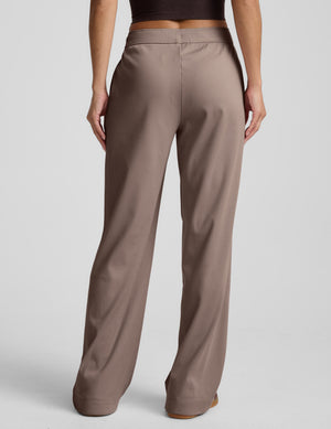 Brown wide-leg corduroy pants worn by a person on a light gray background. 