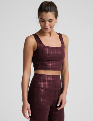 model wearing a red plaid foil printed square neck cropped tank top and matching leggings against a plain background. 