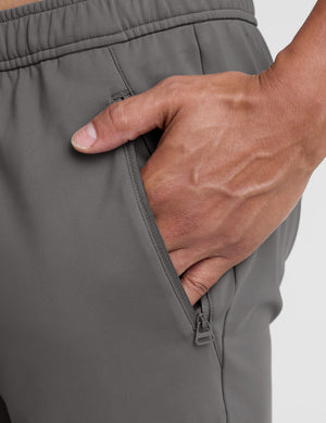man wearing a gray shirt and gray pants on a white background. 