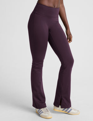 person wearing dark purple pants on a light gray background. 