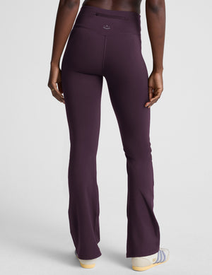 person wearing dark purple pants on a light gray background. 