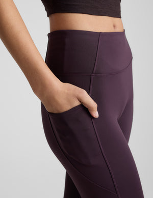 Woman wearing a purple athletic outfit on a light gray background