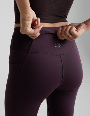 Purple leggings with a logo on a gray background. 