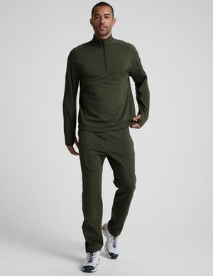 man wearing a green quarter zip pullover against a plain background. 