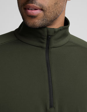 man wearing a green quarter zip pullover against a plain background. 