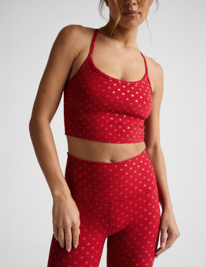 Woman wearing a red hearts printed cropped tank and leggings set on a white background. 