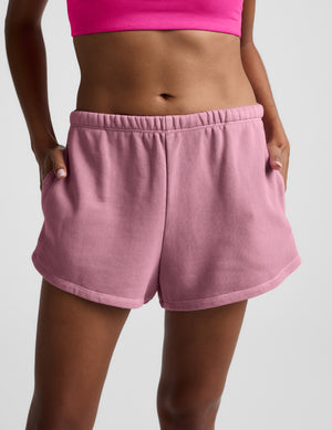 Pink Fade Out Mid-Rise Short featuring a gathered elastic waistband, side pockets, and a curved hem shown on a model.