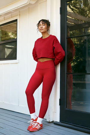 Woman wearing a red fleece sweatshirt and red leggings. 
