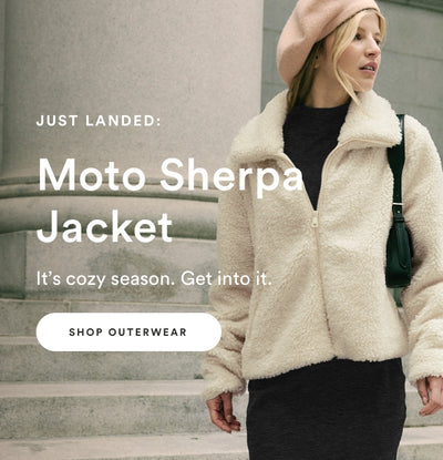 model is wearing a white sherpa zip-up jacket. 