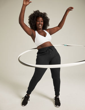 Smiling woman hula hooping in black Heather Rib Street Jogger featuring a high drawstring waist and slim, ribbed leg fit.