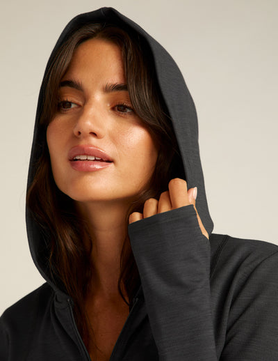 black zip-up jacket with a hoodie and thumb holes. 
