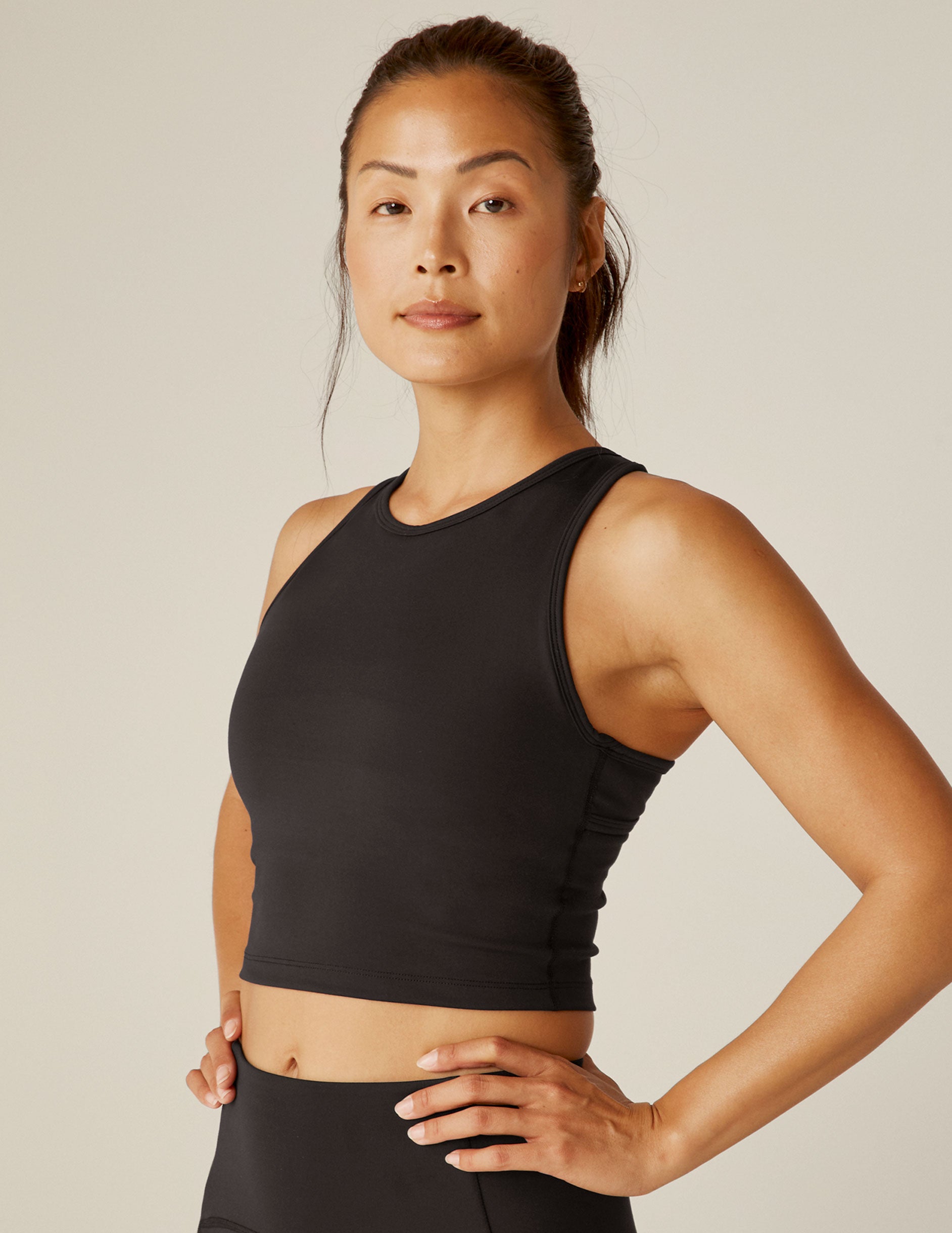 black scoop neck cropped tank with an open back detail held with bartacks.