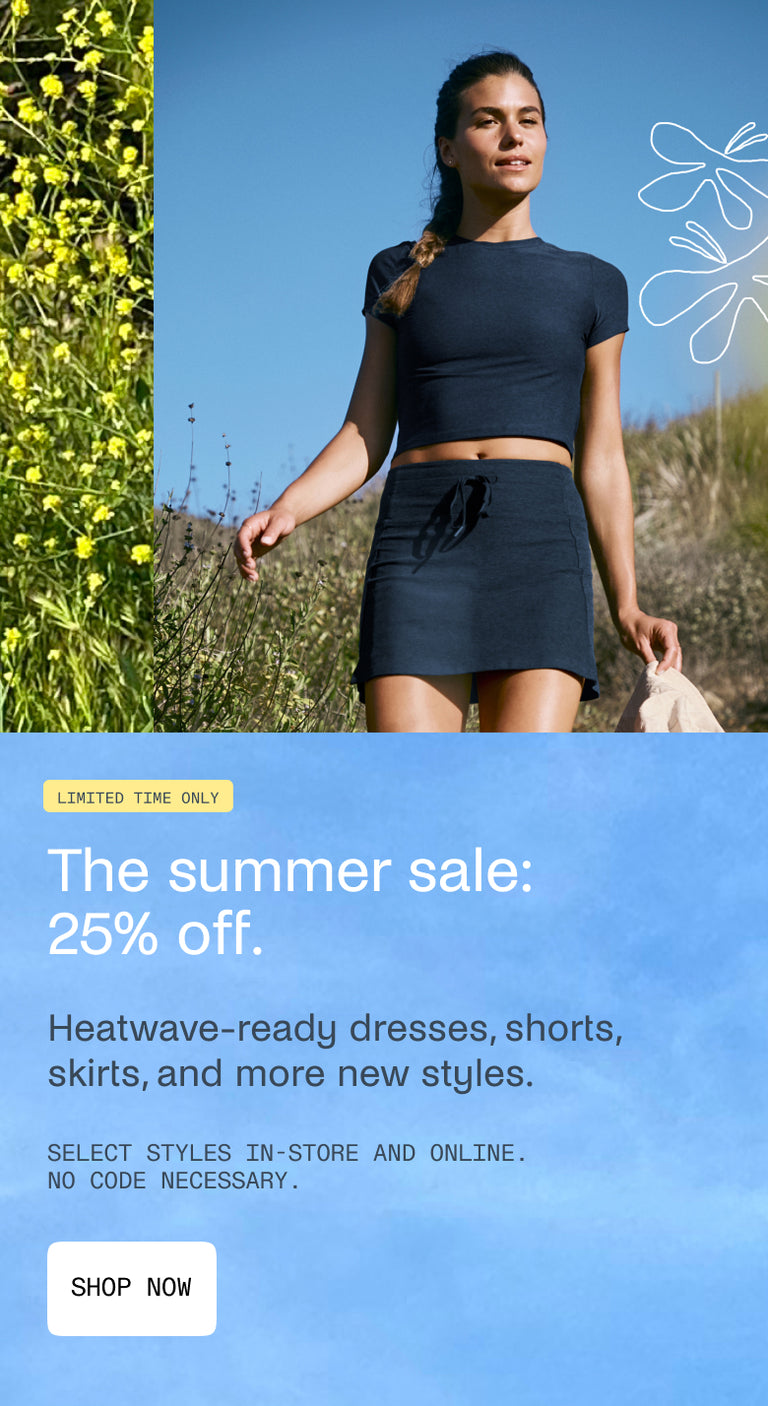 Woman in navy outfit standing outdoors with  text overlay for 25% off summer sale. 