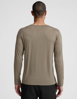 Man wearing a brown long-sleeve shirt against a plain background. 