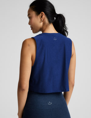 Woman wearing a blue sleeveless cropped top and blue biker shorts against a plain background. 