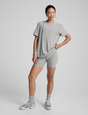 Woman wearing a gray athletic outfit on a plain background. 