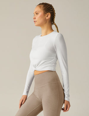white scoop neck featherweight long sleeve cropped top with a front crossover detail. 