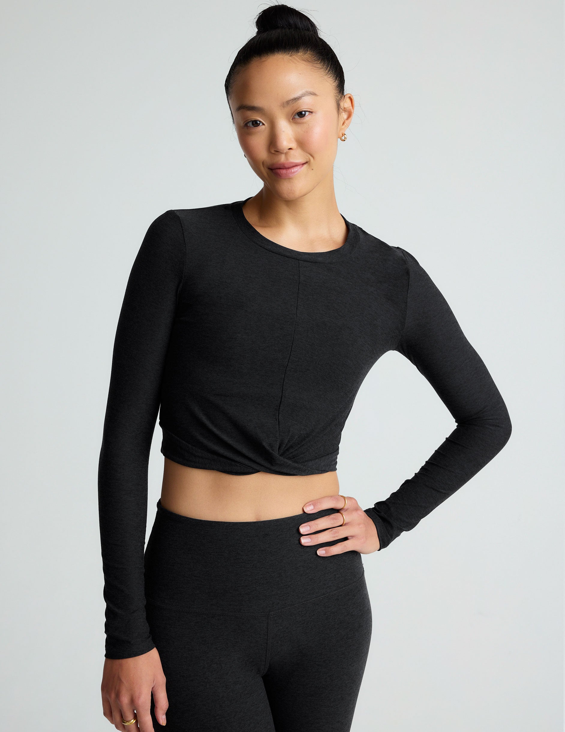 black scoop neck featherweight long sleeve cropped top with a front crossover detail.