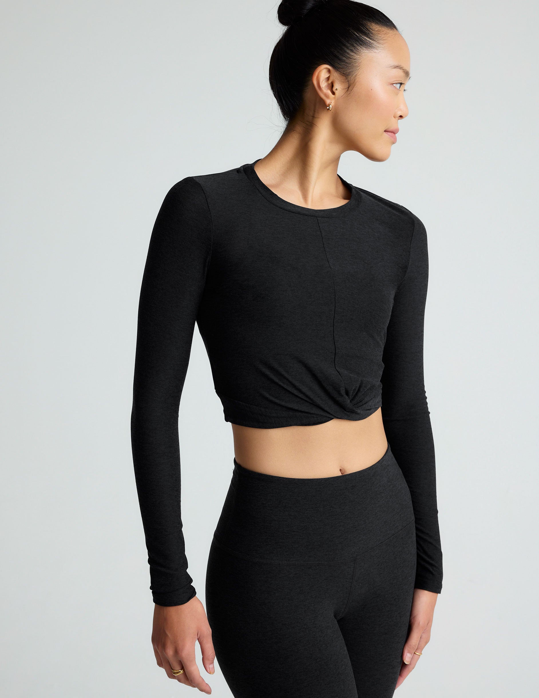 black scoop neck featherweight long sleeve cropped top with a front crossover detail.