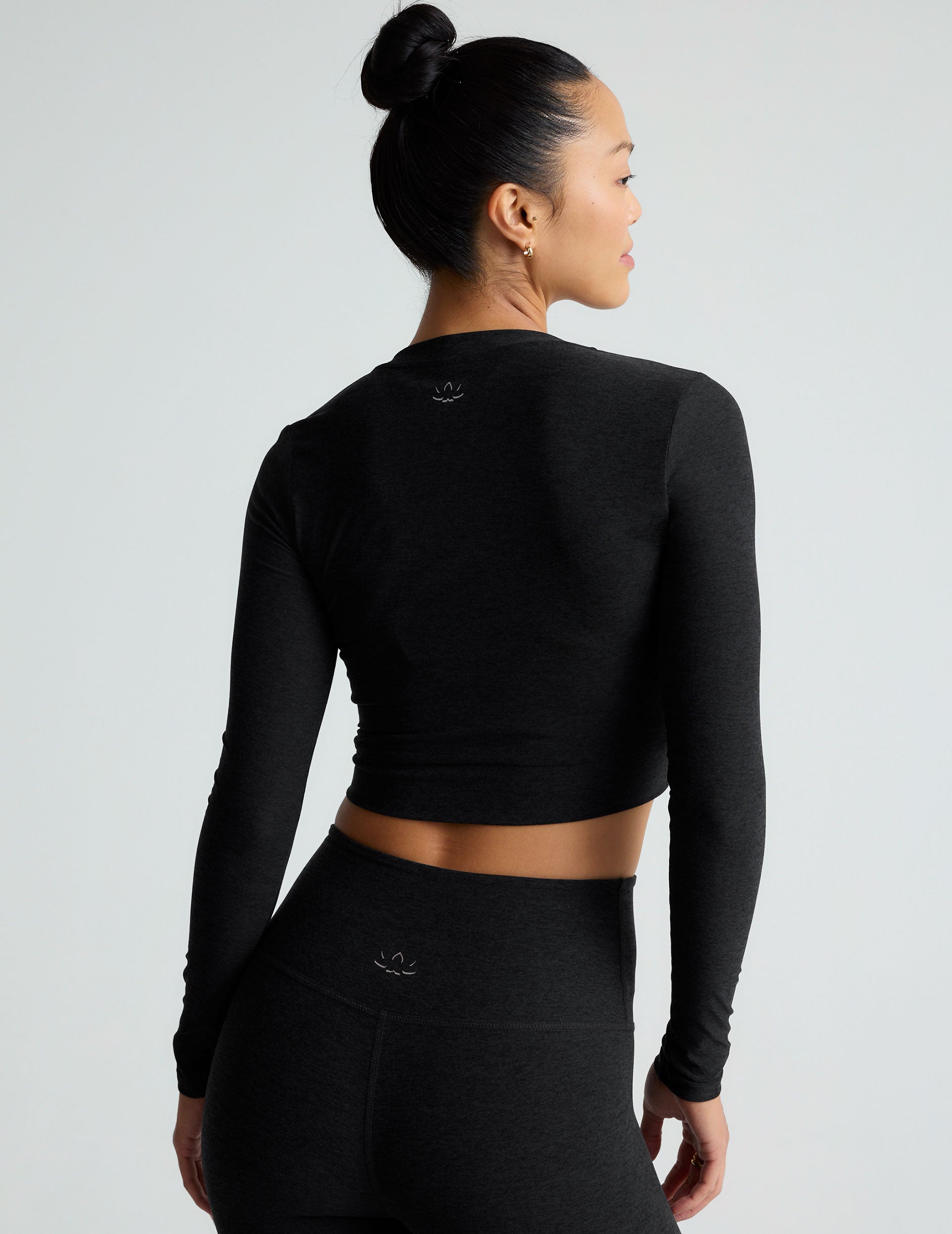 black scoop neck featherweight long sleeve cropped top with a front crossover detail.