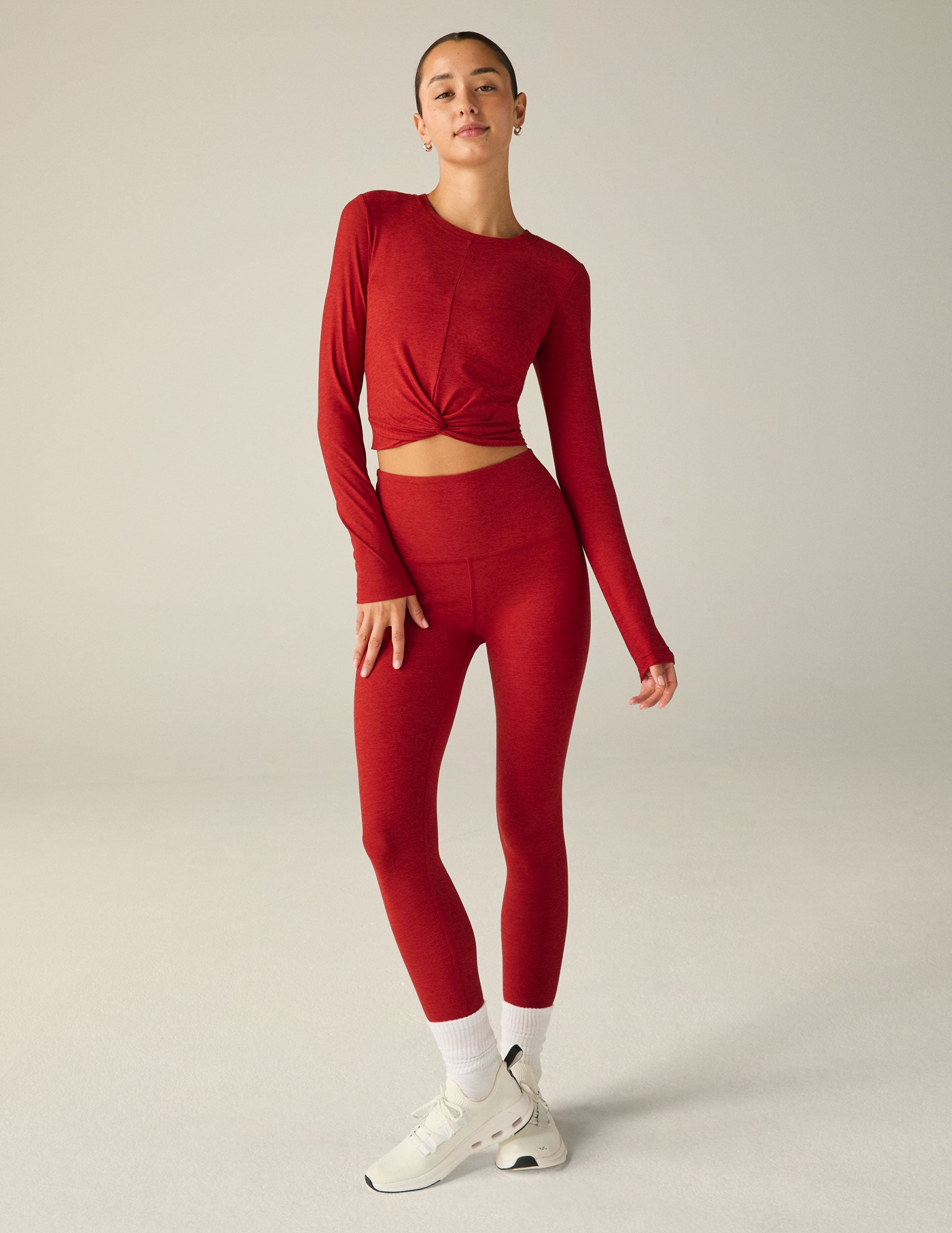 red long sleeve top with a twist detail in front. 