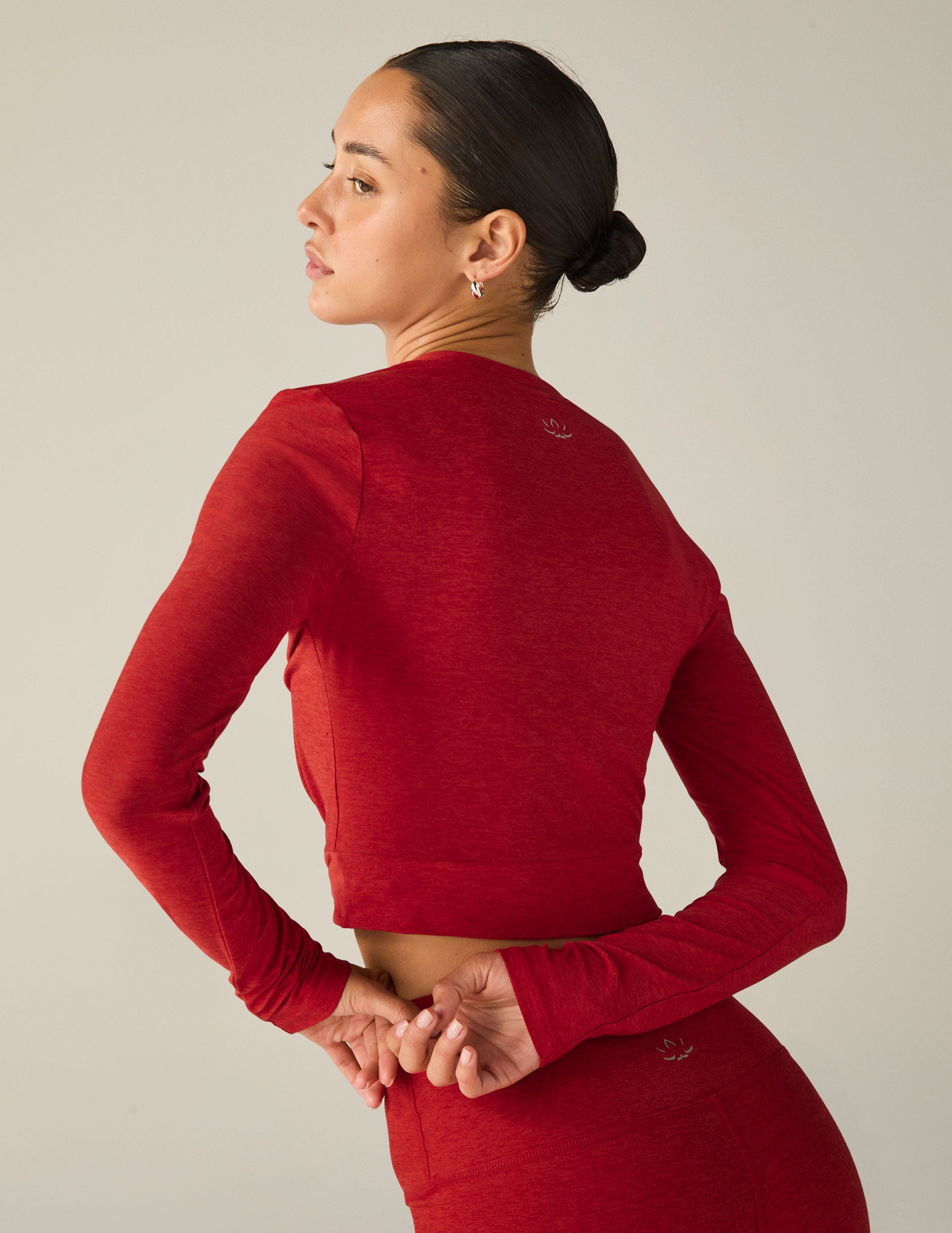 red long sleeve top with a twist detail in front. 