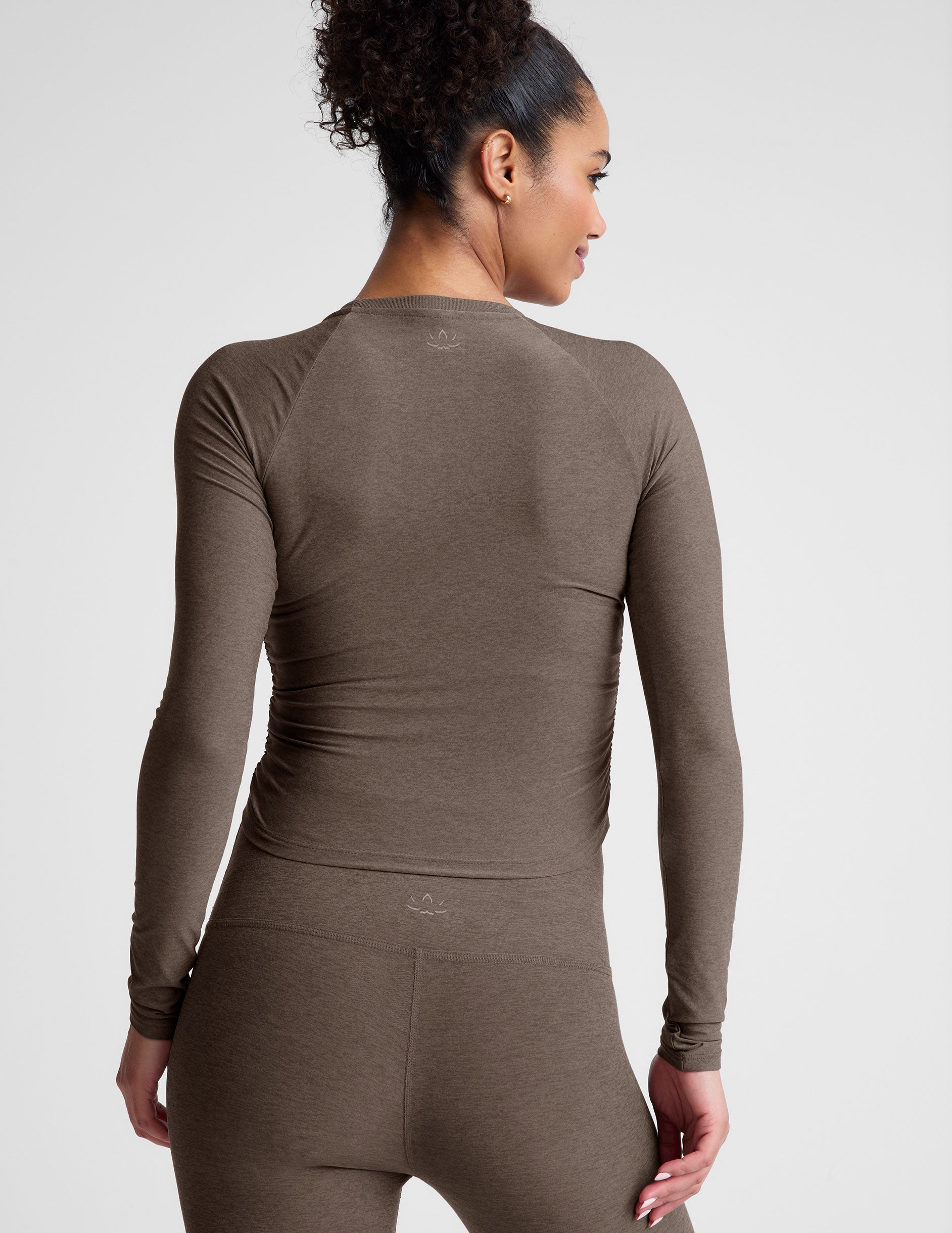 brown long sleeve cropped top with shirred detailing on the sides. 