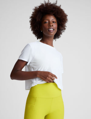 white lightweight loose-fitting cropped tee with a scoop neckline.  
