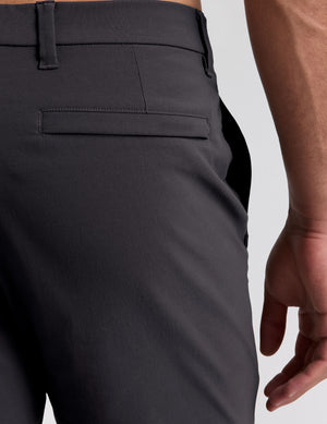 male model wearing a grey t-shirt and chino pants on a light background. 