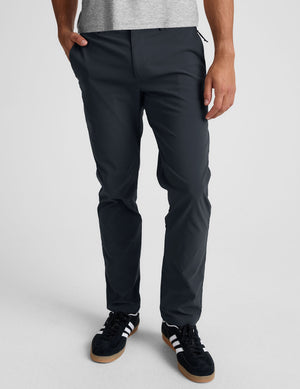 man wearing a gray t-shirt and navy chino pants with pockets against a plain background. 